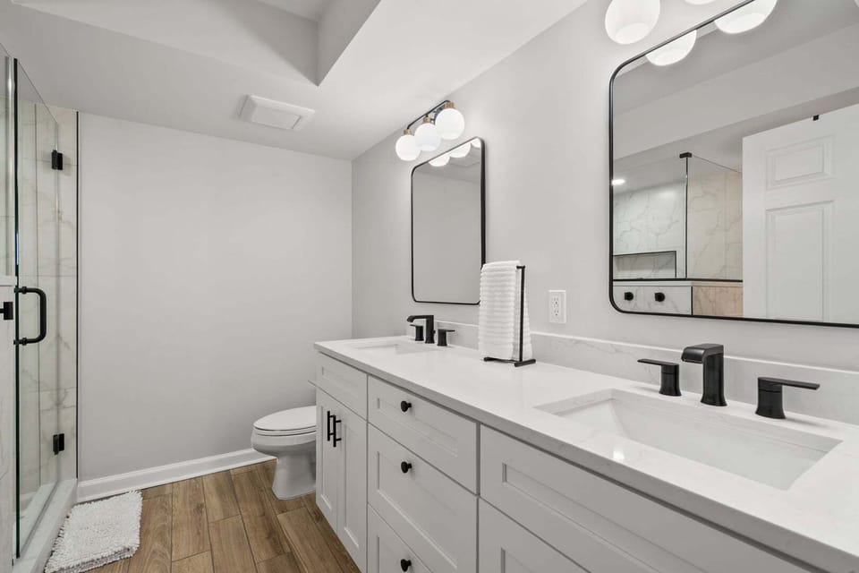 Vanity with two sinks, black faucets and a walk-in shower at North Shore Villas 501, Ocean Drive, North Myrtle Beach