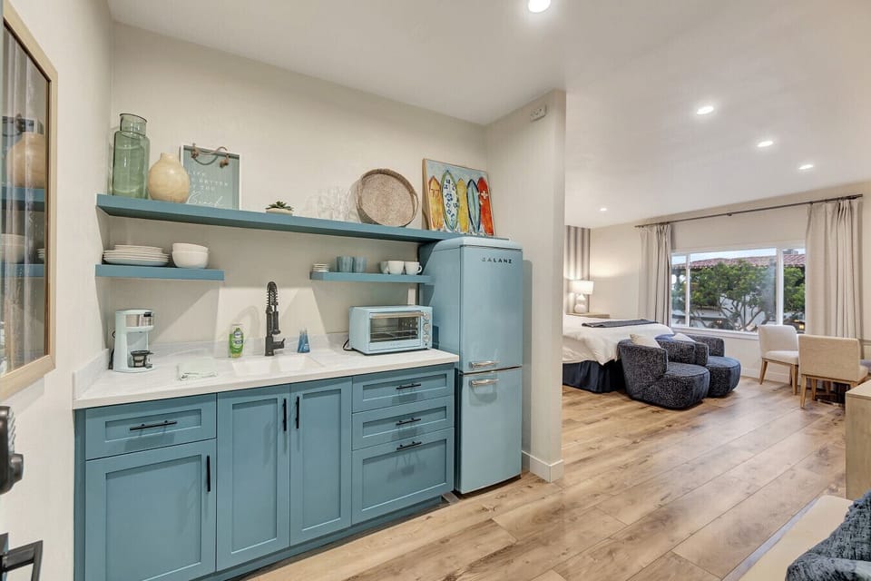 Charming kitchenette w/ retro fridge, open shelves & decor details for a cozy feel