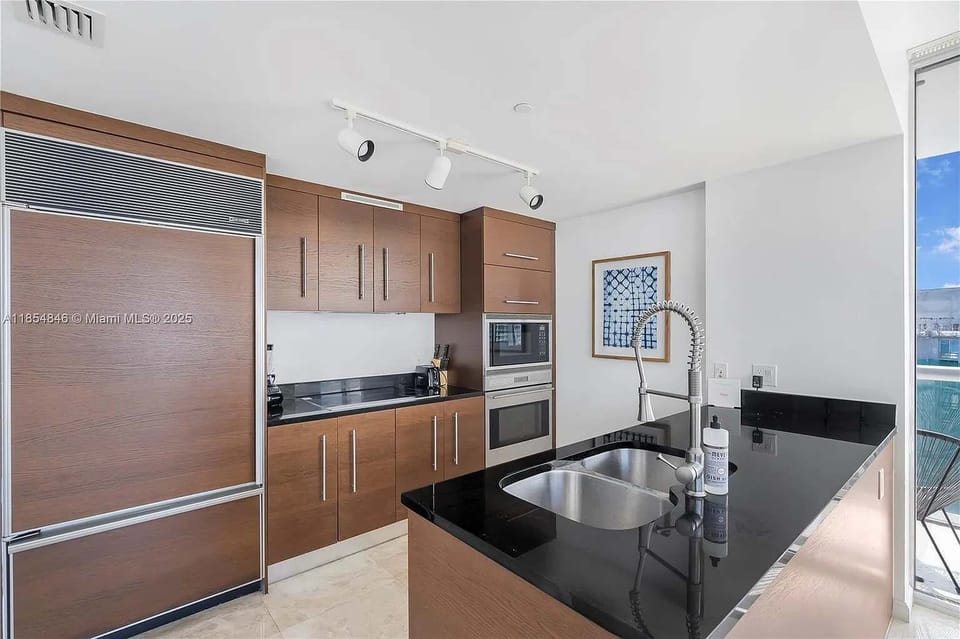 Contemporary kitchen with premium wooden cabinetry and high-end finishes.