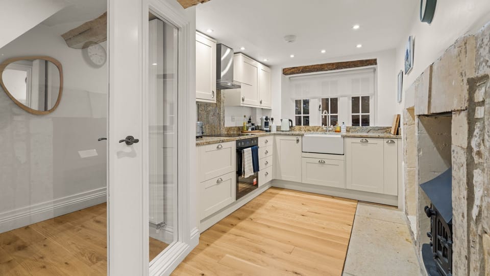 The charming kitchen retains original cottage features and offers a practical space for preparing meals.