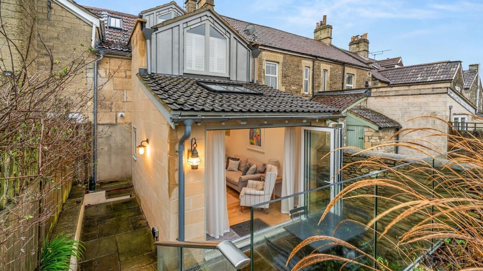 Steps to one side lead up to a lawned garden area, lined with beautiful trees and ideal for quiet birdwatching.