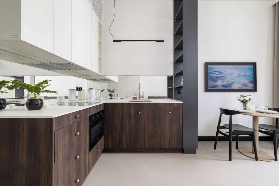 Modern kitchenette with wood-finish cabinets and clean countertop workspace.