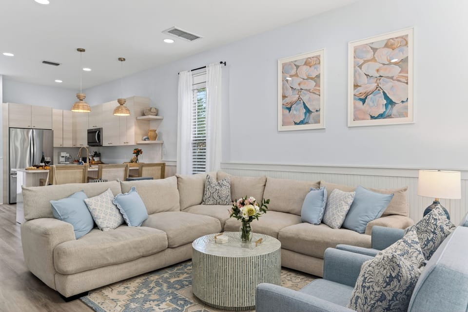 Spacious sectional sofa with blue accent pillows and coastal wall art.