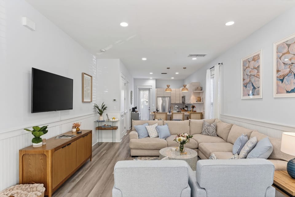 Wide-angle view of the living area flowing into the dining and kitchen spaces.