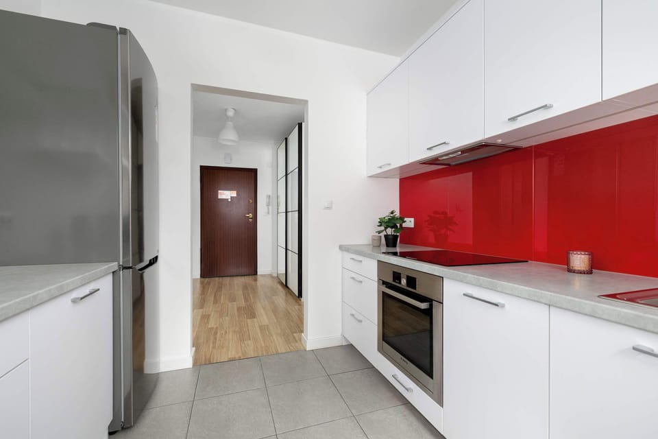 Kitchen view with oven, fridge, and cabinets.