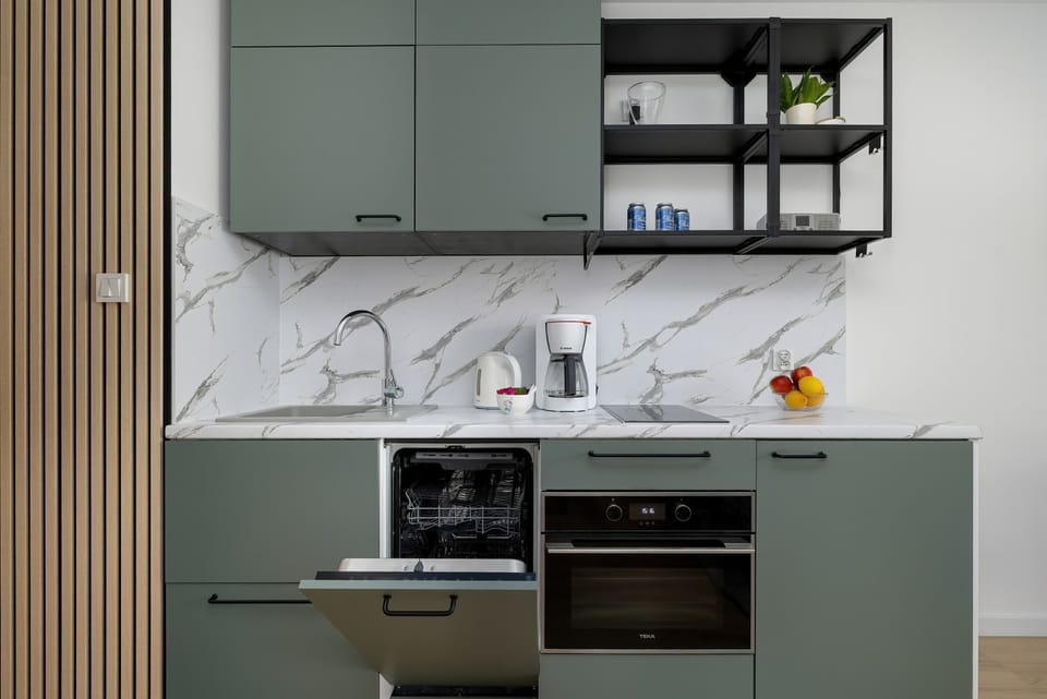 Modern kitchenette with oven and storage.
