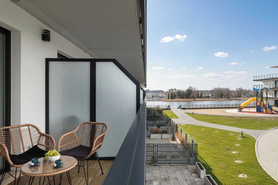 Balcony with seating and open neighborhood view.