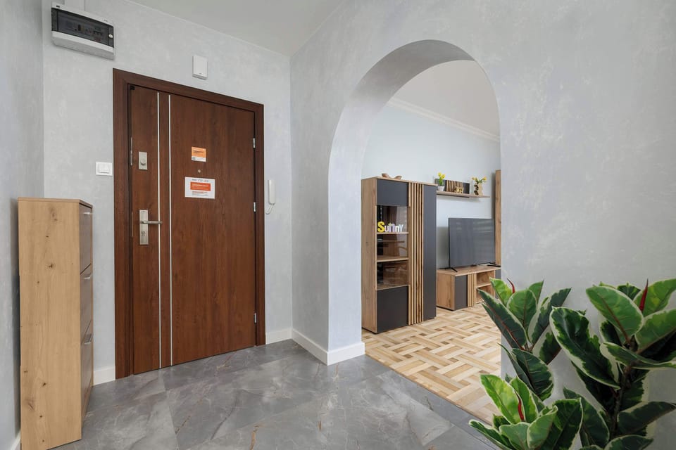 Spacious corridor with a wooden wardrobe and modern décor. Natural light creates a welcoming feel.