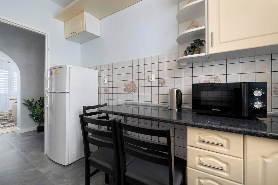 Kitchen with stove, cabinets, and window. Neutral tones and functional design make cooking easy.