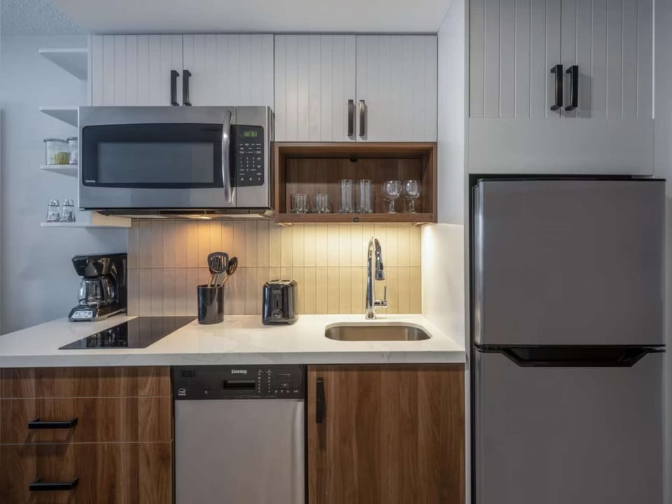 Compact kitchen with fridge, microwave, sink, and cooking tools