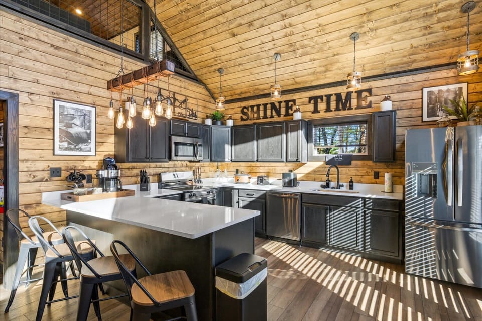 A fully equipped chef's kitchen with dark cabinetry and industrial mountain charm.