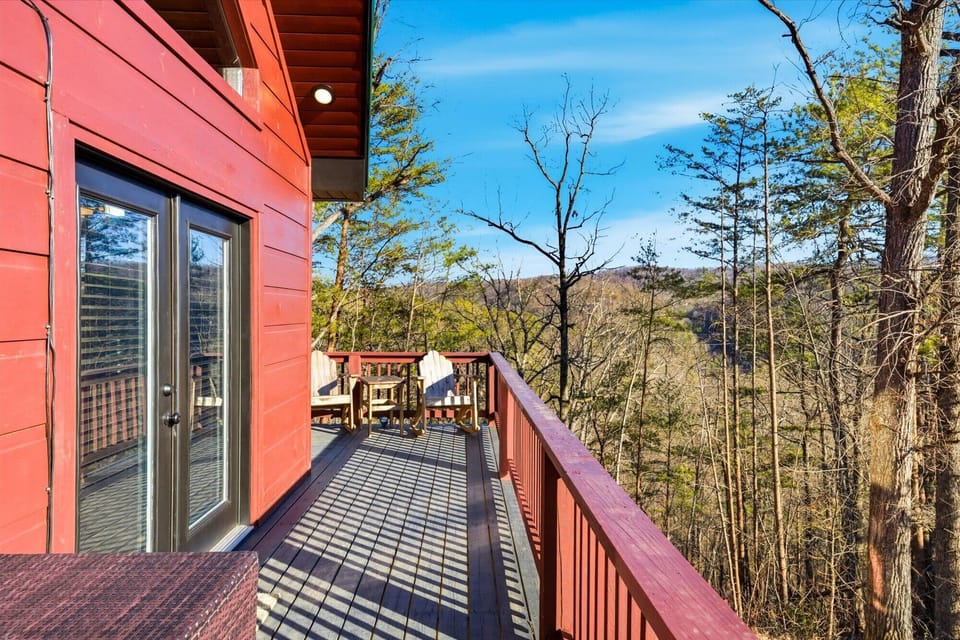 Expansive deck with Adirondack seating and sweeping forested mountain views.