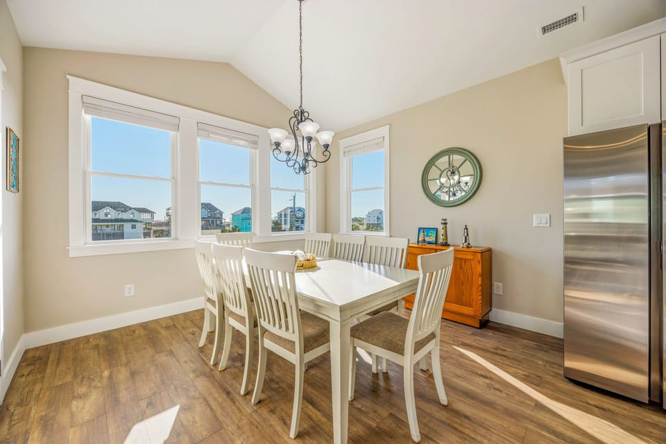 Gather around your bright dining table with stunning views of the surrounding neighborhood through expansive windows that fill the space with natural light.
