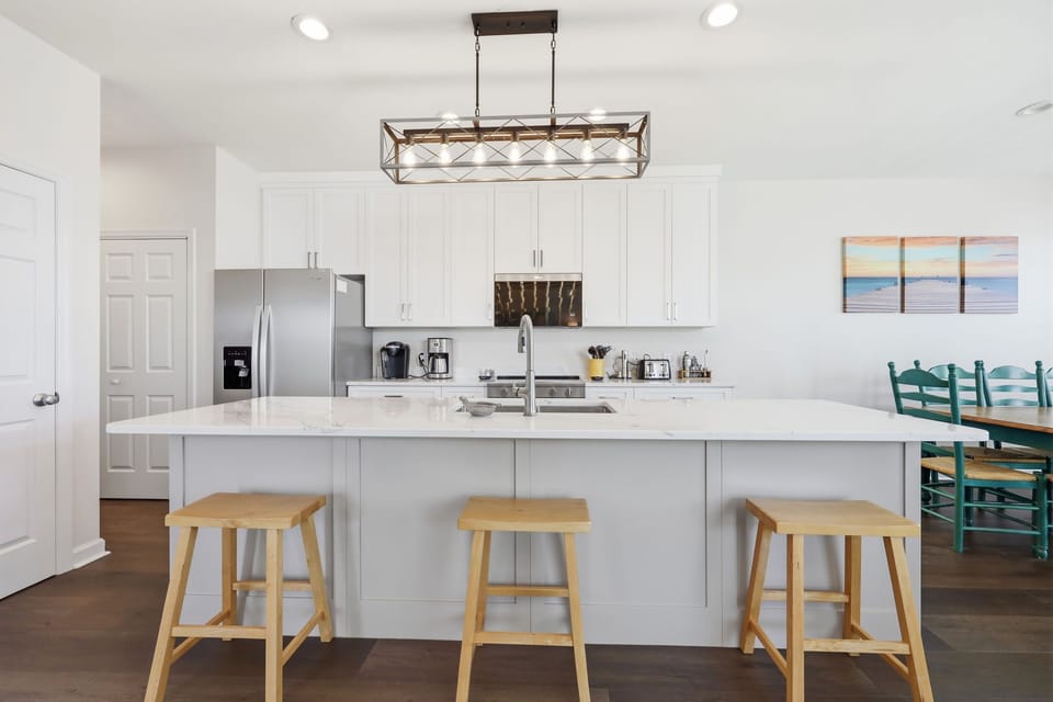 You'll love preparing meals in this bright, open kitchen with its generous island, modern appliances, and soothing coastal touches throughout.