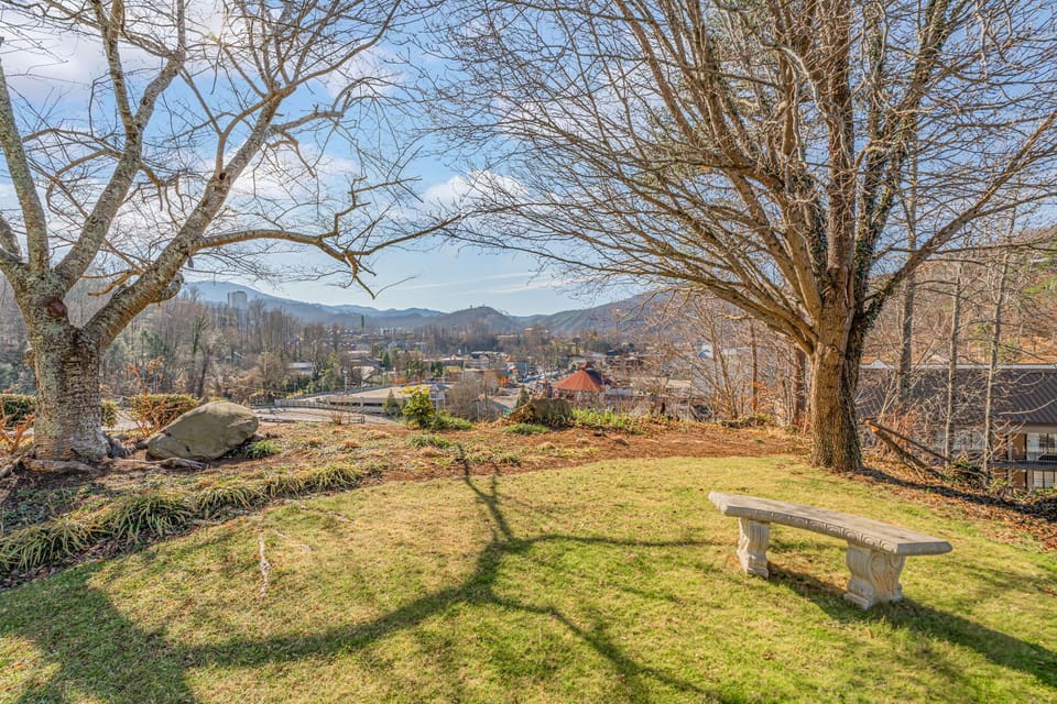 Peaceful garden space with mountain views and stone bench offers a serene spot to unwind and enjoy the surrounding landscape.