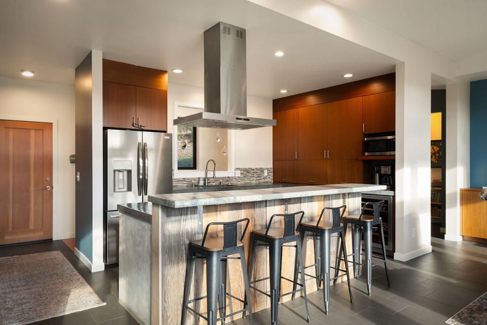 Sleek kitchen island beckons with stylish bar seating, perfect for morning coffee or evening conversations over culinary creations.