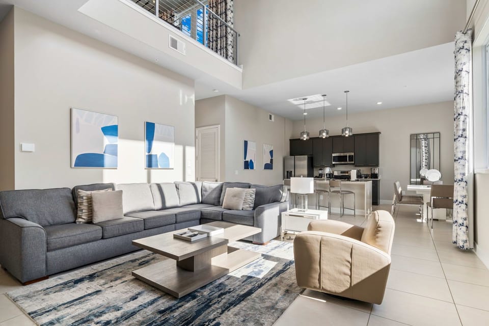 Large sectional and leather accent chair centered around a 65” smart TV—perfect for relaxing together.