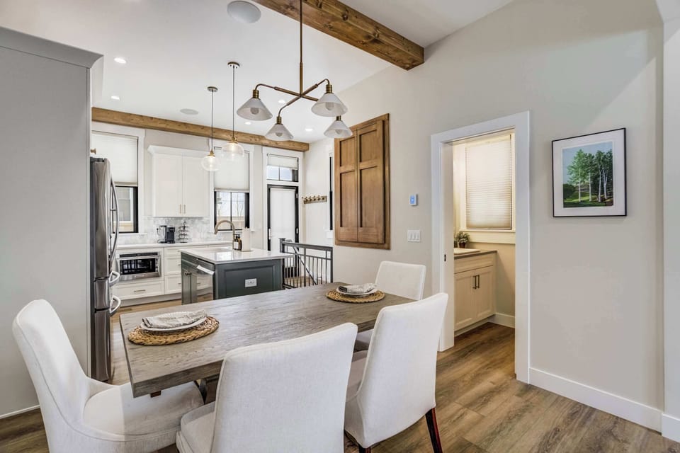 Gather around the spacious dining table for shared meals or evening board games. The contemporary lighting and comfortable seating make this area a central hub for social activity, located perfectly between the kitchen and living room.