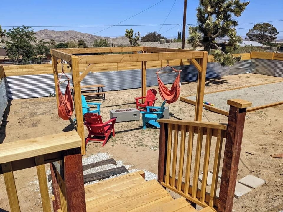 Stairs leading to the outdoor pergola, hammocks, fire pit & chairs