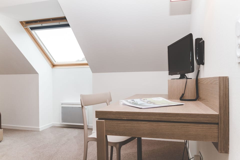 Bathed in natural light, this inviting workspace is ideal for lingering breakfasts or planning a day along the Breton coast.