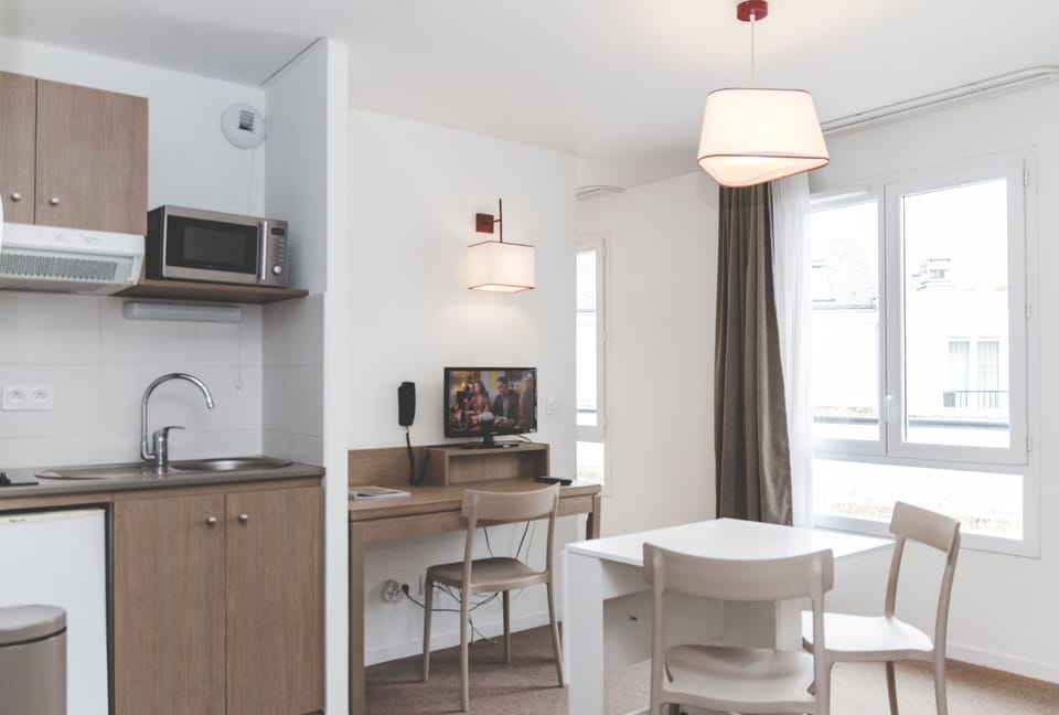 A well-organised kitchenette sits next to the dining table, ideal for simple meals during your stay.