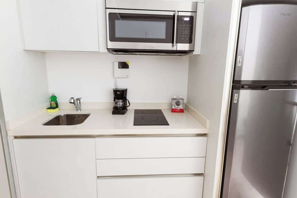 The kitchen is equipped with an electric stove, microwave, coffee maker, and toaster. Everything is ready to make you feel at home.