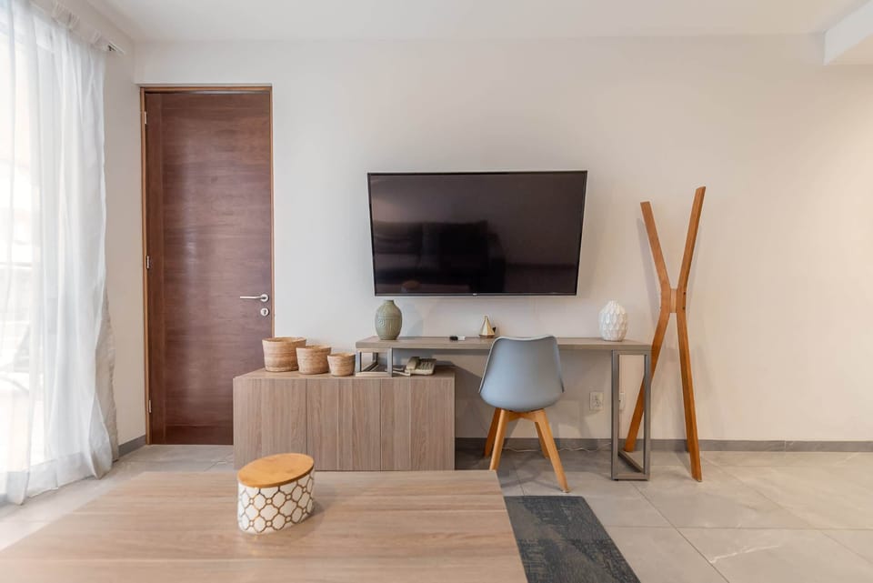 Relax and unwind in this stylish living area, with a TV and workspace.
