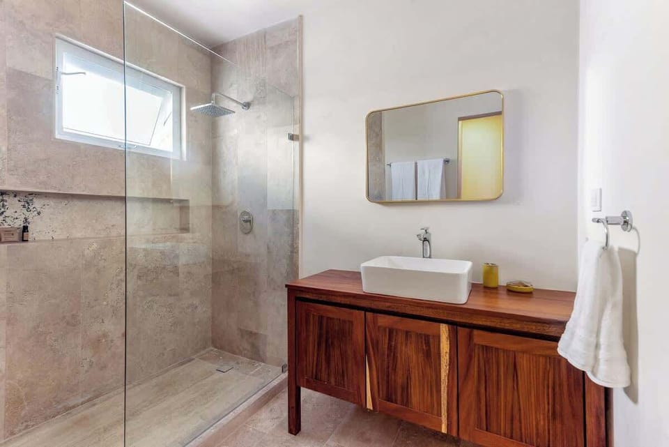The bathrooms feature spacious showers and a lot of modern design.