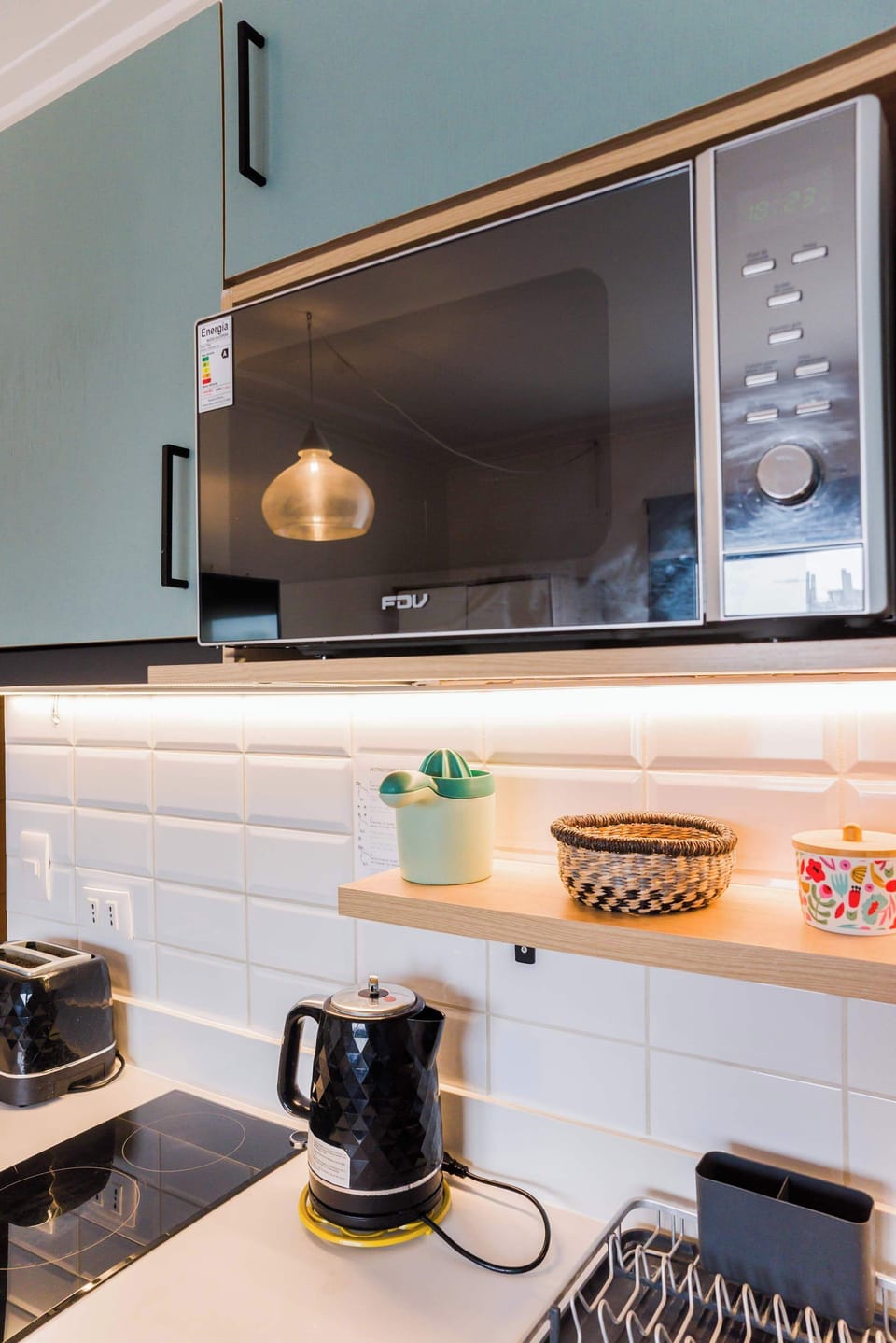 Modern kitchen with sleek appliances and stylish decor, perfect for cozy meals.