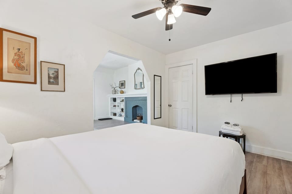 Wake up to natural light and classic charm in this peaceful bedroom with a flatscreen TV.

