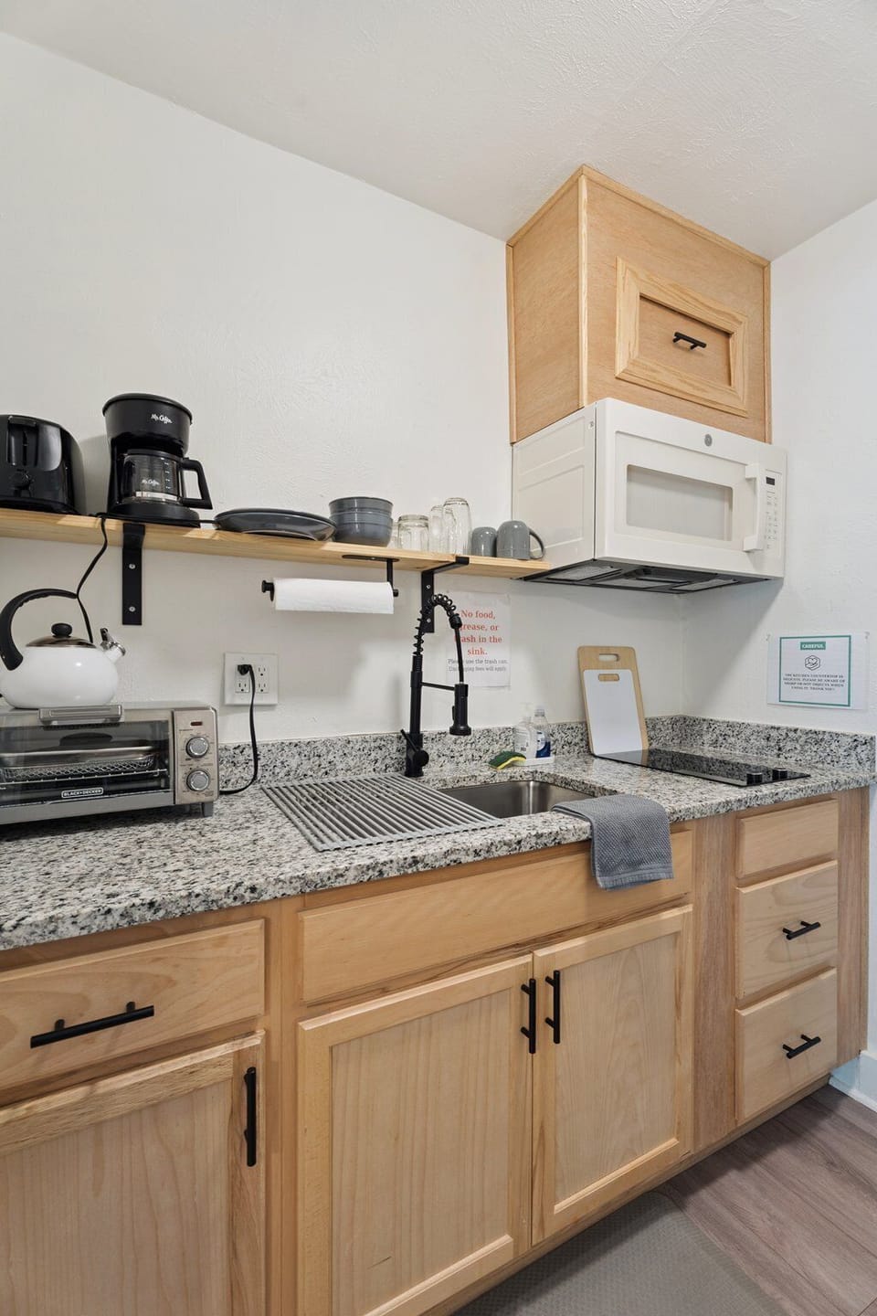 The efficient kitchen is equipped with a mini fridge, microwave, two-burner cooktop, and the essentials you need to prep simple meals.