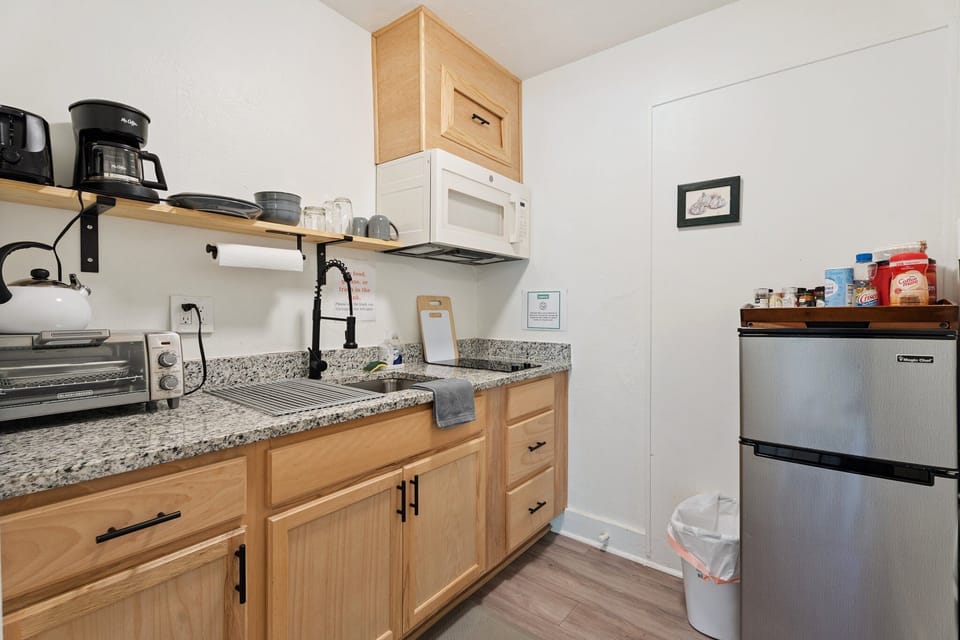 This compact kitchen offers both form and function, with updated cabinetry, granite counters, and a full set of essentials.

