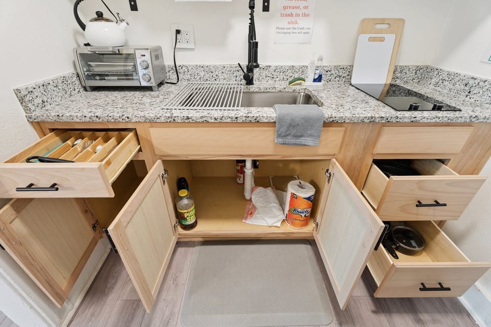 Everything you need, right where you need it—cutlery, cookware, and cleaning supplies are neatly organized and ready to go.