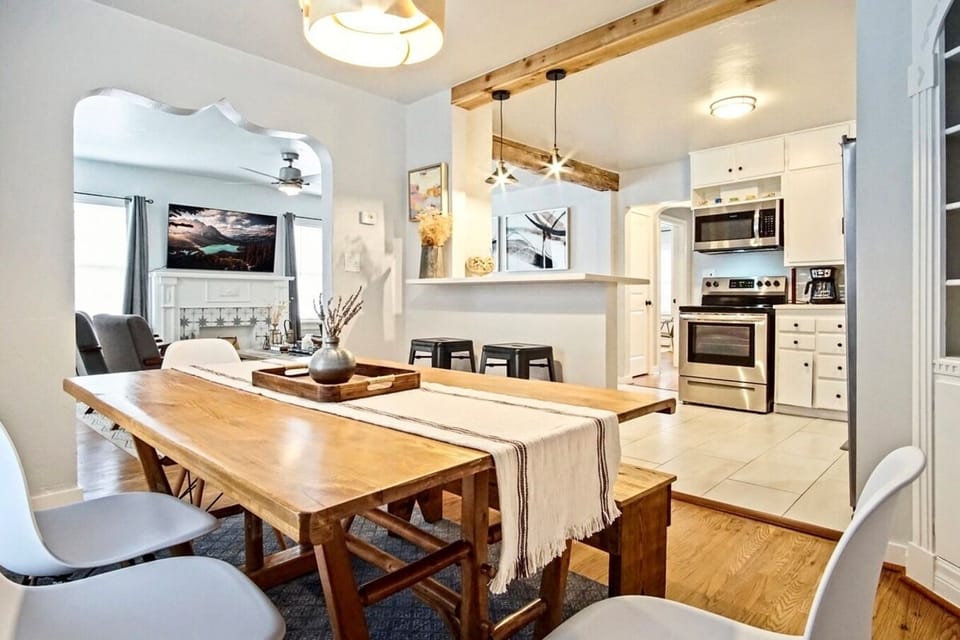 A modern kitchen with sleek stainless steel appliances, white countertops, and light wood cabinets.