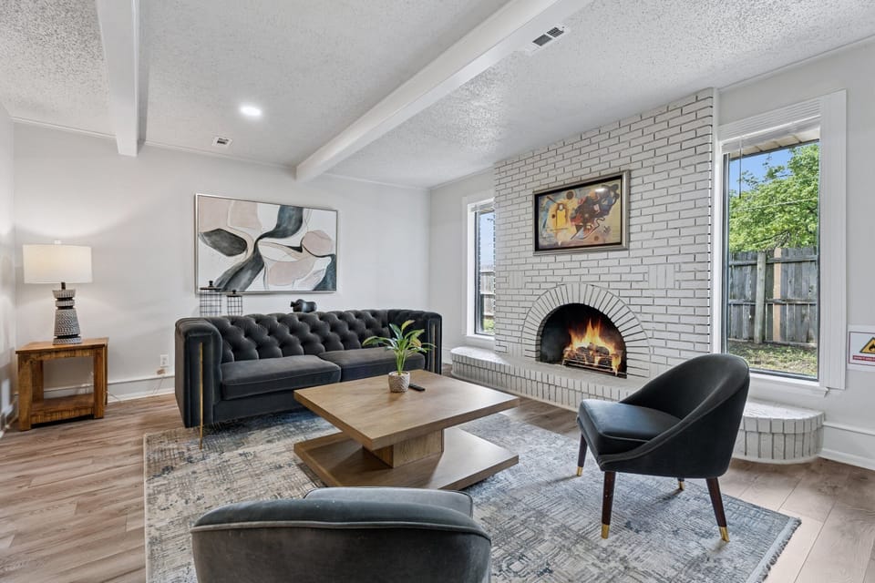 Unwind in this designer living room with plush seating and natural light. (Fireplace is not real or available for use)