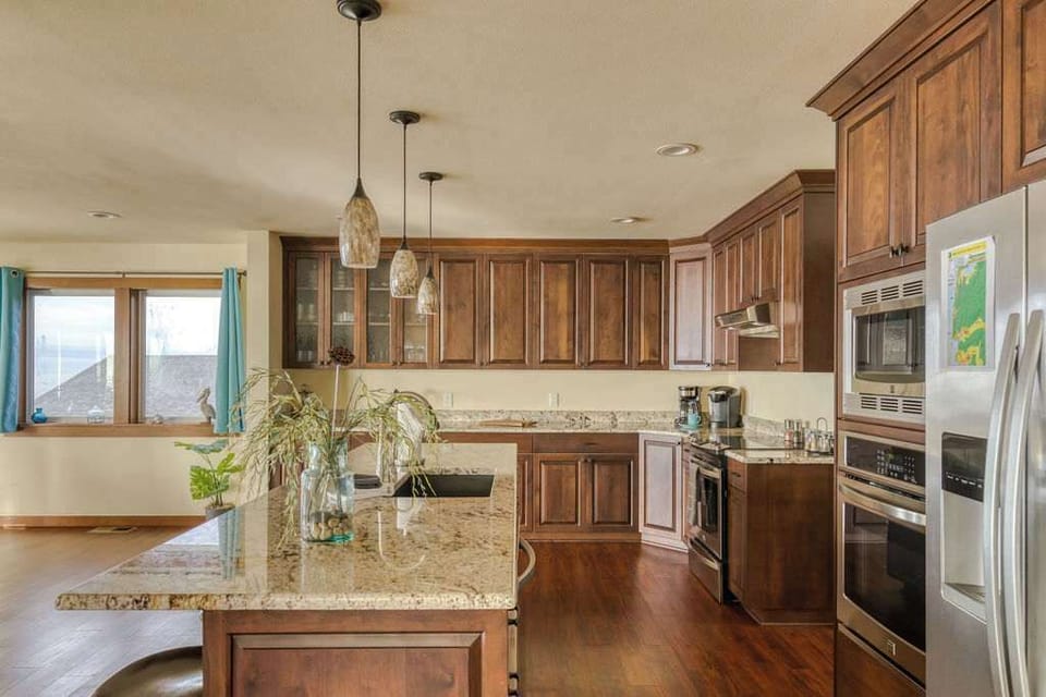 Dark wood cabinetry, granite counters, and full stainless appliances — everything you need to cook in.