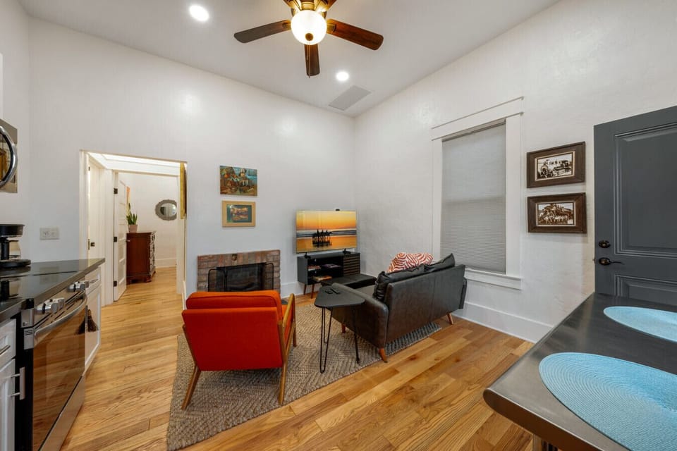 Cozy, open concept space with kitchen, living room area with electric fireplace, and dining table for two