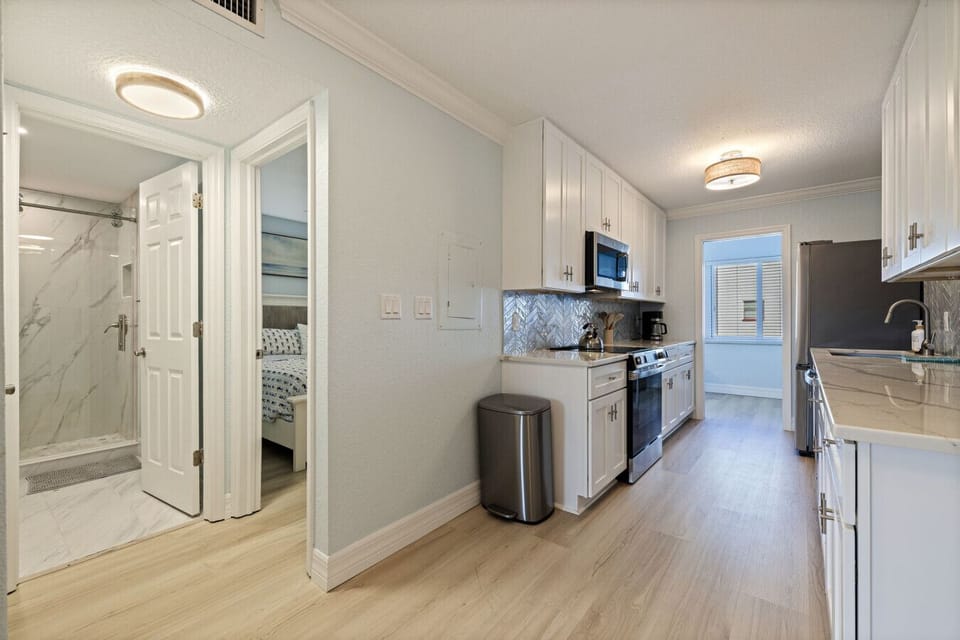 Spacious open layout offering a glimpse of the kitchen and hallway to the bedroom and bath