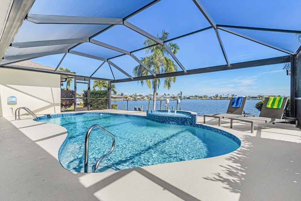 The electric-heated pool has a water feature and picture cage windows giving an unobstructed view of the lake