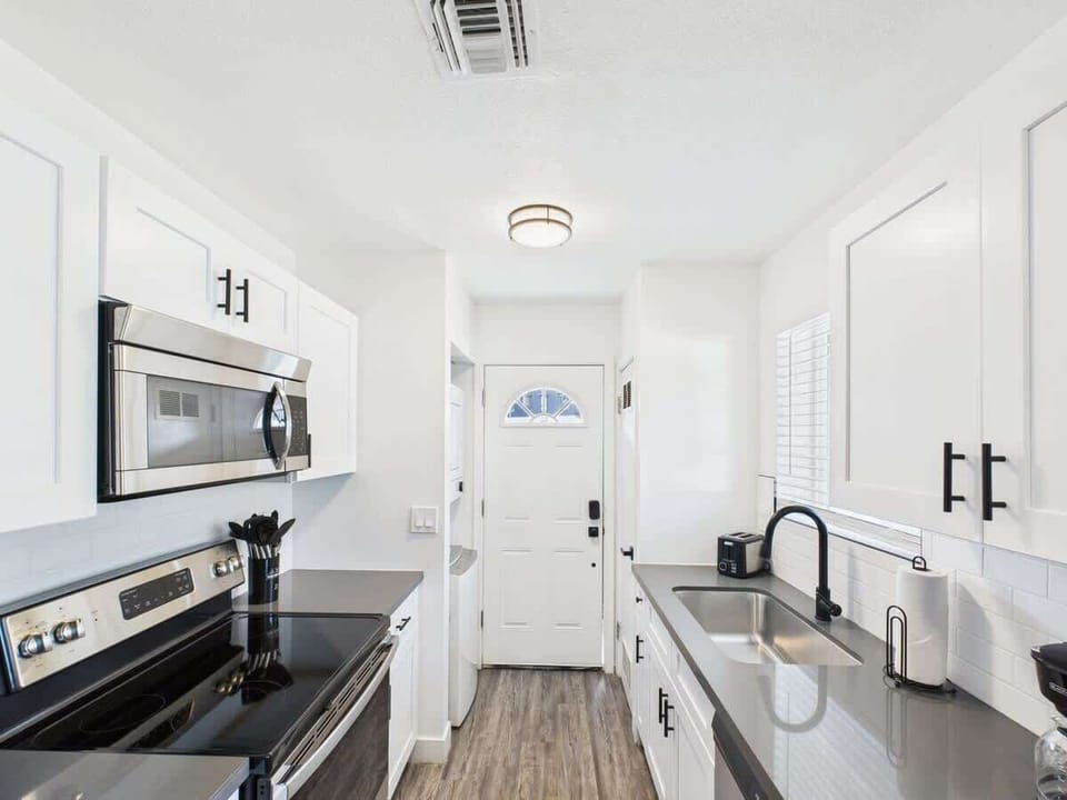 Unit 1: Fully equipped kitchen stocked with basic cooking essentials, stainless steel appliances, access to the shared backyard, and a washer and dryer.