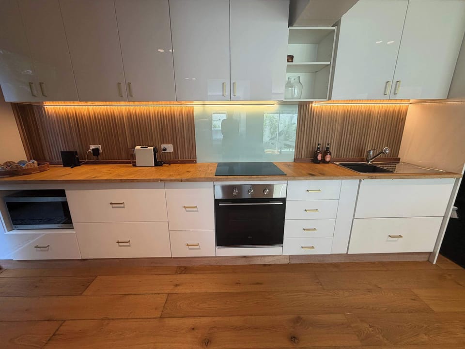 Refurbished kitchen with modern appliances and generous bench space