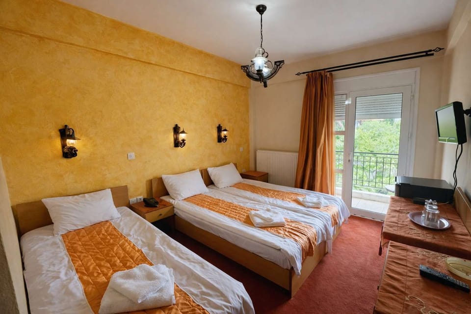 Triple Bedroom with Warm Colors and Traditional Decor
Comfortable twin beds in a cozy room featuring warm tones, textured walls, and soft lighting.