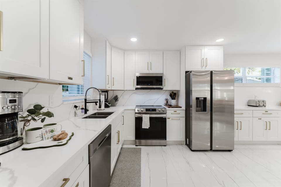 Bright, open-concept kitchen with quartz countertops, stainless steel appliances, and abundant prep space—perfect for family meals and entertaining. Fully stocked with premium coffee setup, modern finishes, and seamless flow to dining and outdoor areas.