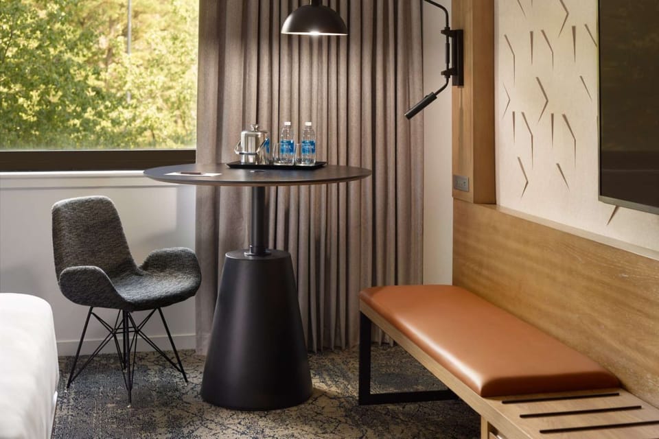 Round table with chair, bench, and water by the window