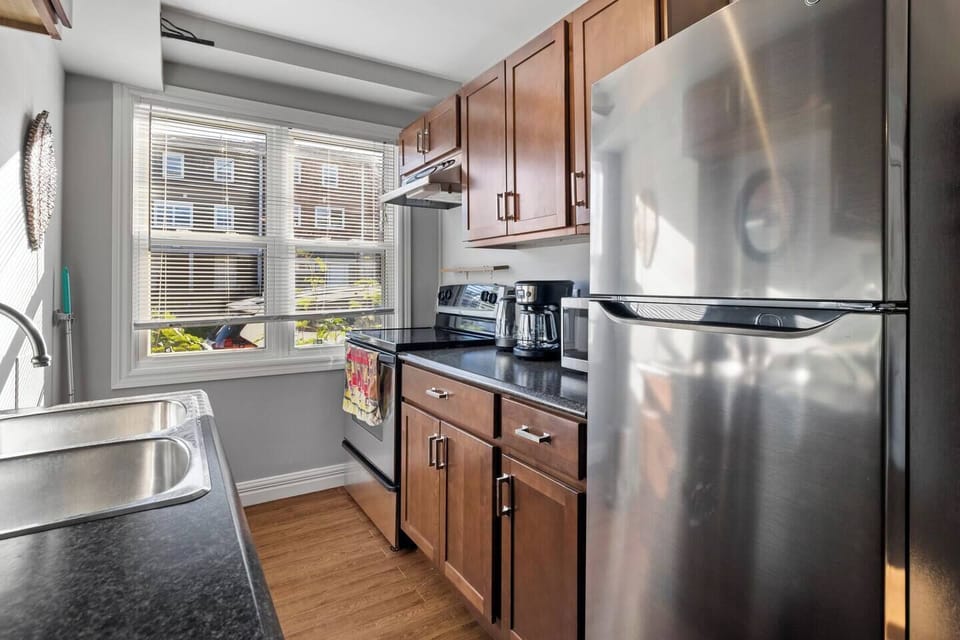 Kitchen contains, small slow cooker, personal blender, bowls, utensils, cutlery