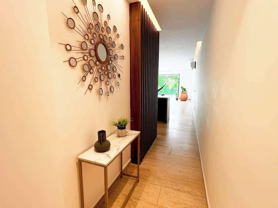 Entrada con decoración cálida y moderna que te da la bienvenida a tu refugio tropical