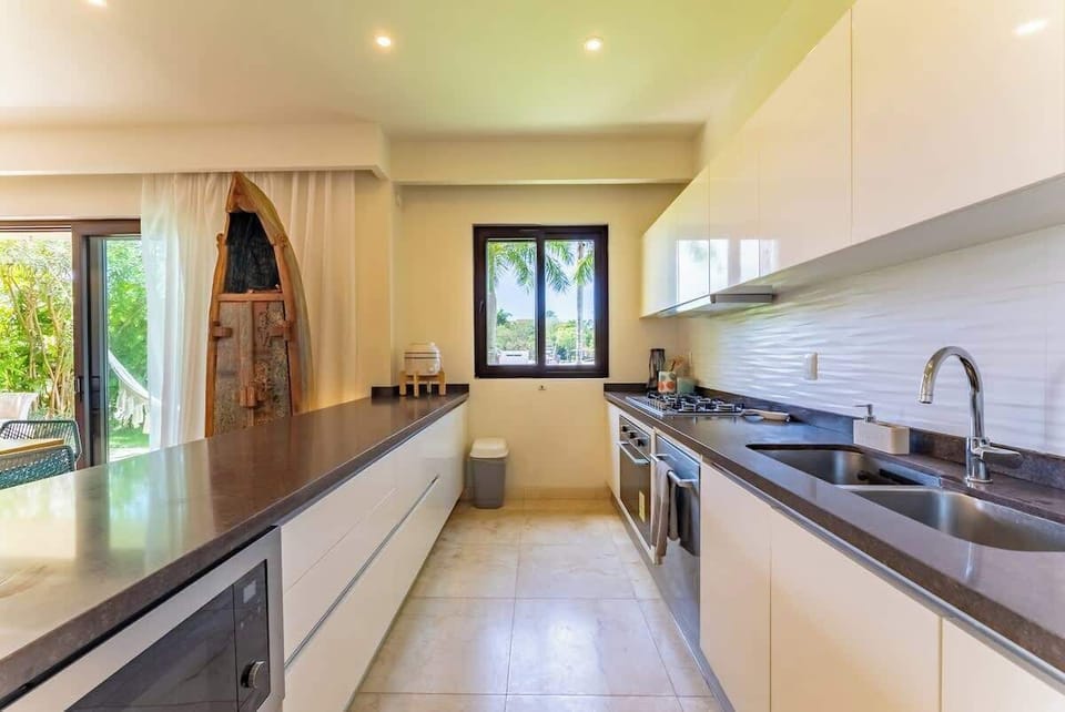 “Cocina abierta con isla central y vista a la naturaleza, ideal para reuniones familiares o cenas con amigos.”
