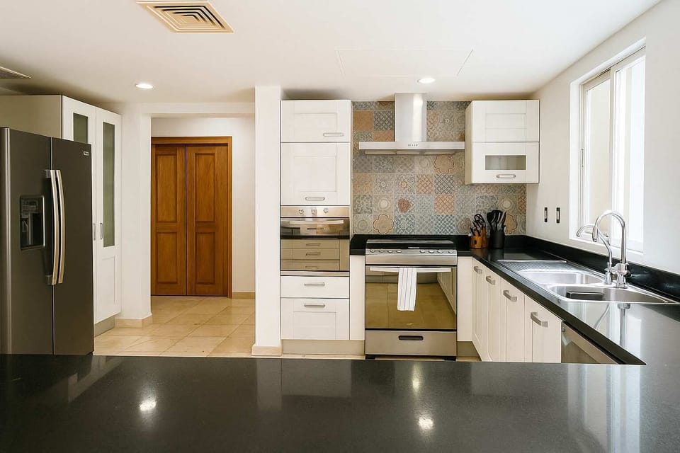 Cocina moderna totalmente equipada — estufa, horno, refrigerador doble y barra amplia. Perfecta para estancias largas y familias.