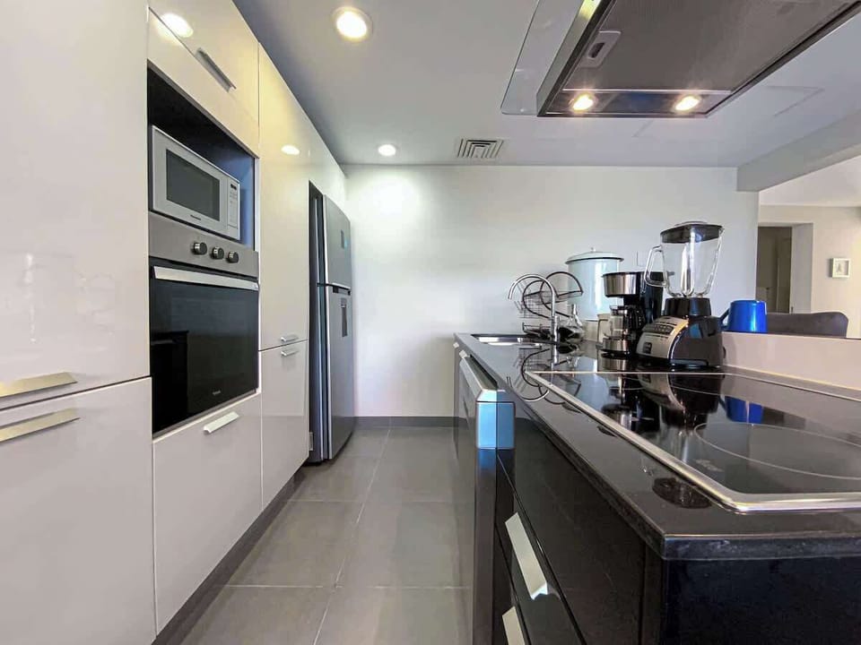 Cocina con electrodomésticos de acero inoxidable, horno, microondas, cafetera, licuadora y refrigerador: lista para que te sientas como en casa.