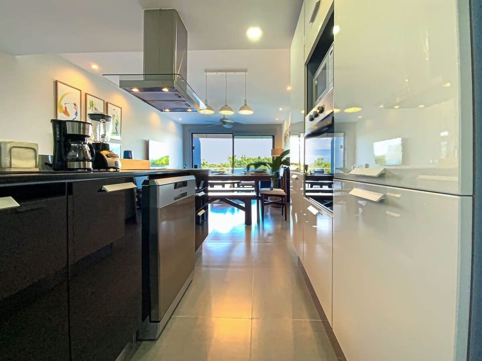 Cocina abierta con barra central e iluminación natural, perfecta para preparar tus platillos favoritos o simplemente disfrutar de un café con vista.